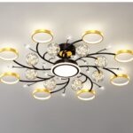 Lustre chambre adulte circulaire et moderne en verre et fer noir et doré fixé sur un plafond et allumé par LED.