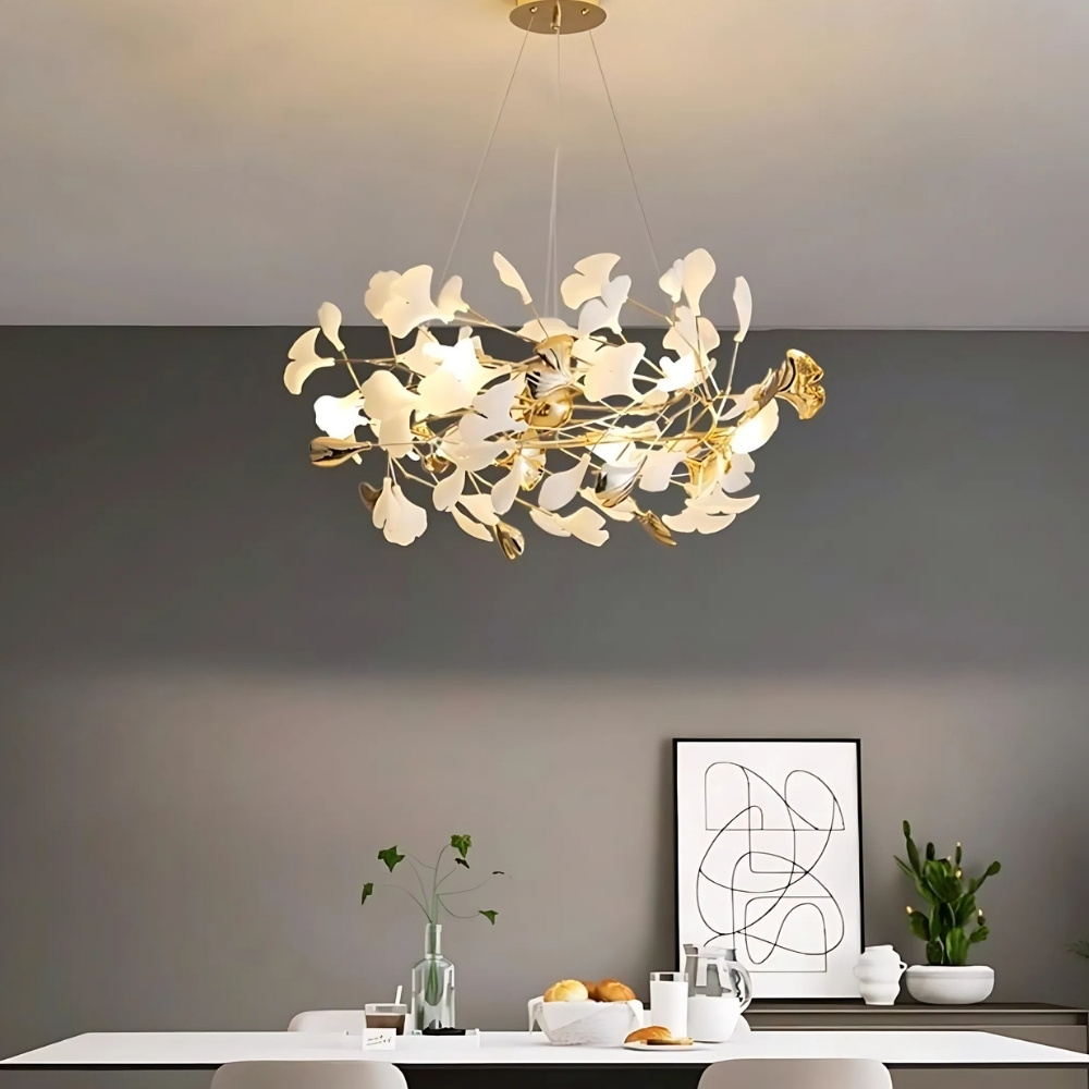 Lustre feuille au design nordique blanc et doré dans une salle à manger au dessus d'une table à manger moderne