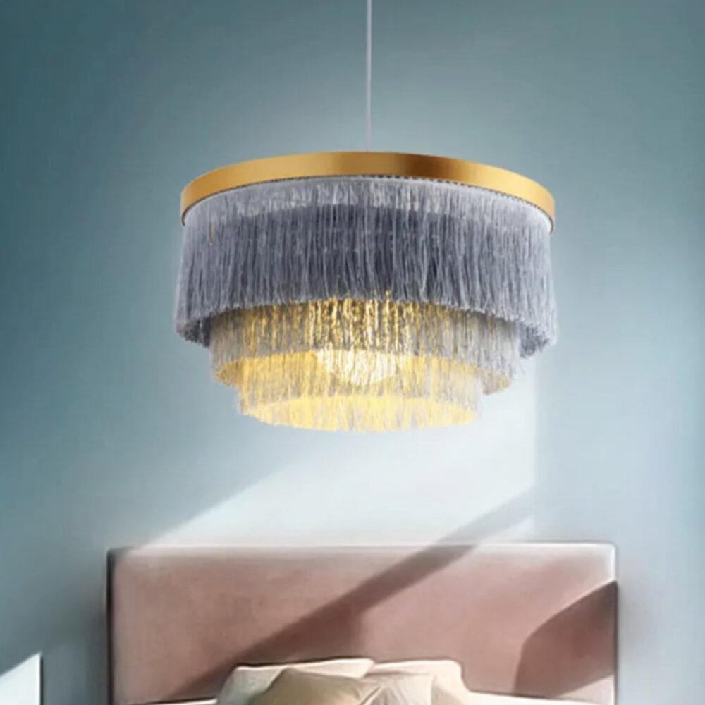Suspension bohème ronde à franges au-dessus d'un lit dans une chambre bleue