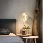 Suspension de chambre design en forme de boule, composé de 2 anneaux dorés à côté d'un lit