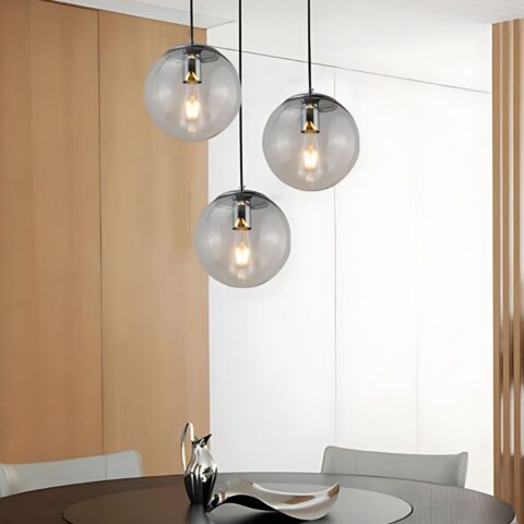Suspension globe en verre design moderne de couleur noire présentée 3 fois au-dessus d'une table à manger