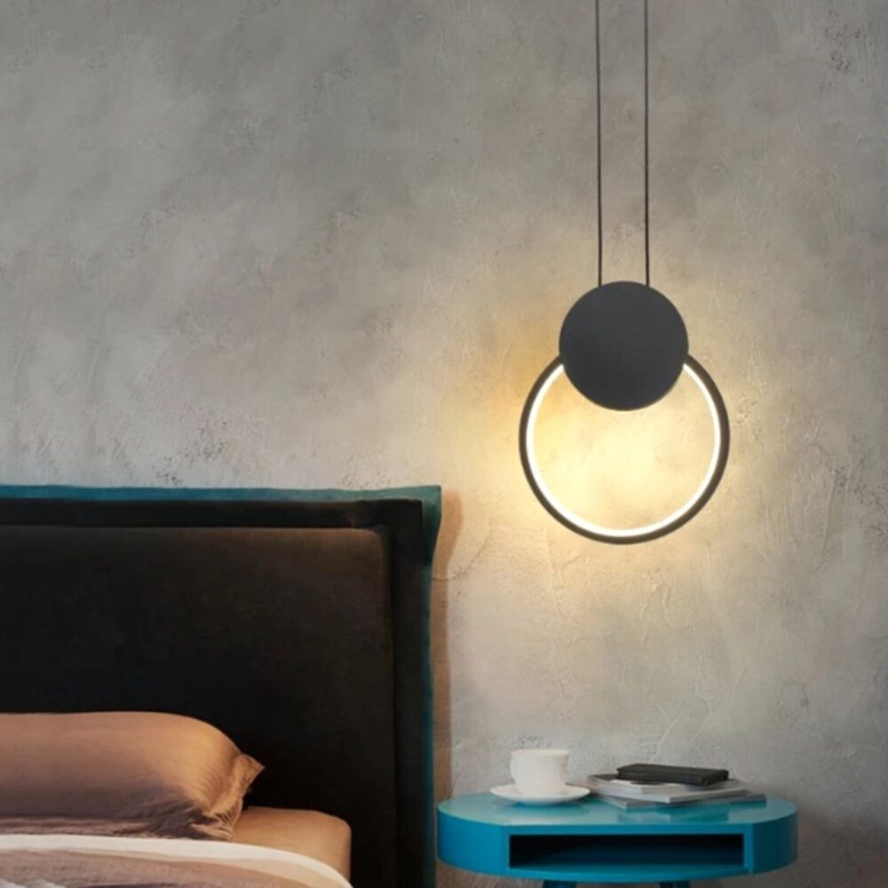 Suspension LED design minimaliste anneau noir au dessus d'une table de chevet pres d'un lit