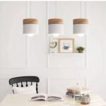 Suspension scandinave en bois présentée 3 fois installée au dessus d'une table à manger