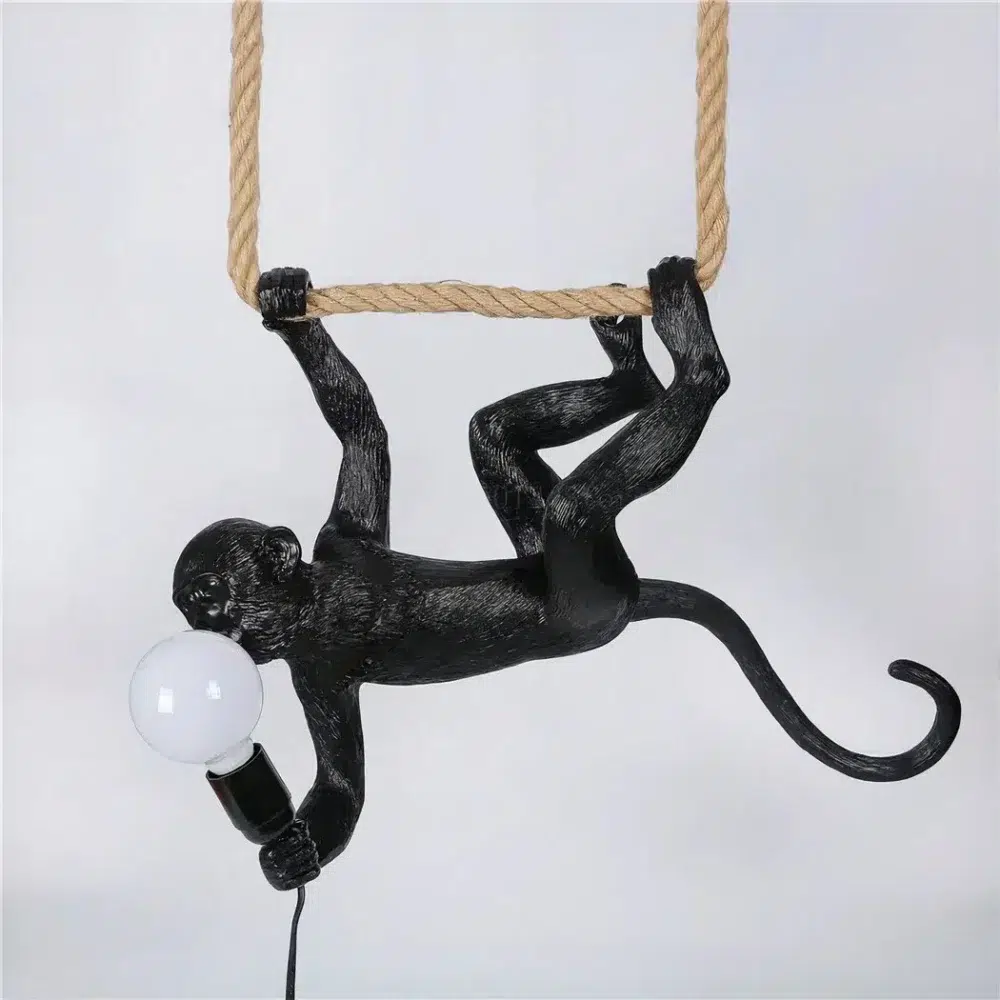Suspension en forme de singe noir suspendu à l'envers tenant une ampoule