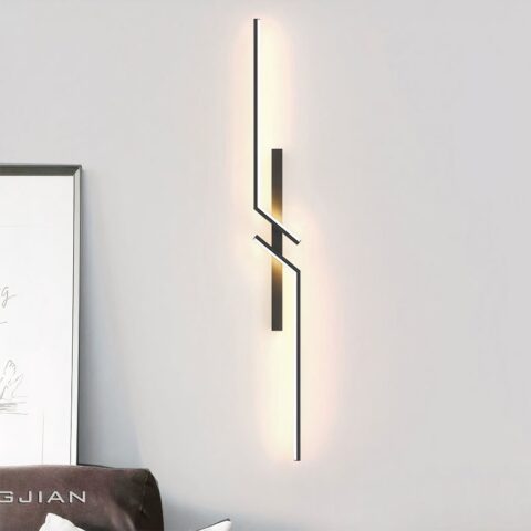 Applique murale noire, géométrique en miroir. accroché sur un mur blanc.