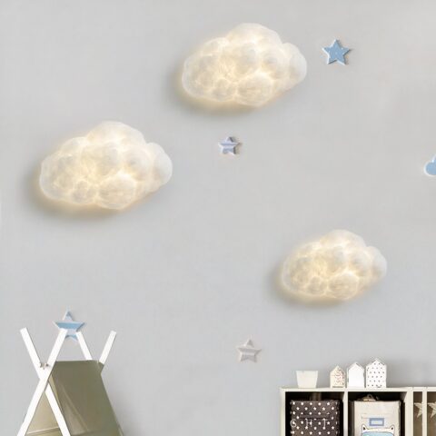 Sur un mur blanc on voit trois appliques murales en forme de nuage blanches allumées.