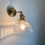 Applique murale en verre élégante et moderne, support de couleur doré et l'abat jour est en verre transparent, avec lumière blanche