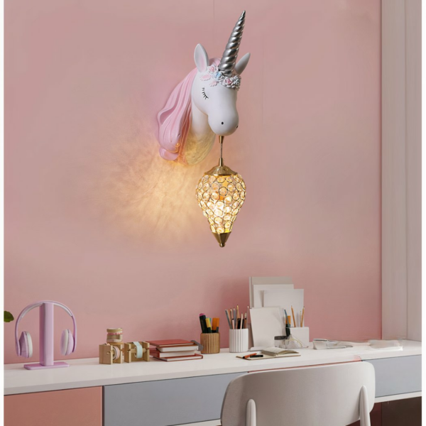 Applique murale enfant en forme de licorne en résine sur fond rose avec un bureau