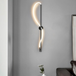 Applique murale LED noire ondulée au-dessus d'un petit vase fleuri