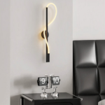Applique murale LED noire ondulée près d'un réveil sur la table de chevet