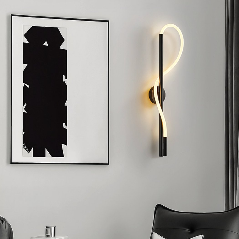 Applique murale LED noire ondulée à côté d'un tableau abstrait noir et blanc