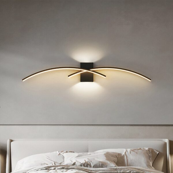 Applique murale intérieure LED au design arc de cercle minimaliste et moderne dans une chambre au dessus d'un lit
