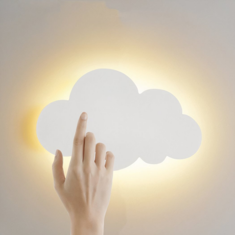 Sur un fond blanc on voit une applique murale en forme de nuage blanc, allumée et une main de femme sur le nuage.