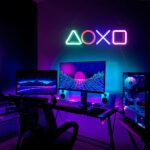 Dans un bureau de gamer on voit au mur une applique murale néon au style futuriste allumée.