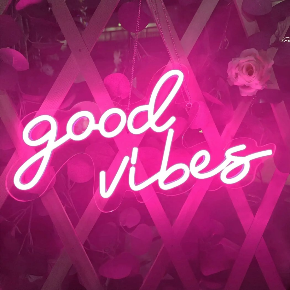 Applique murale néon rose good vibes On voit une applique murale néon rose avec l'écriture good vibes allumée.