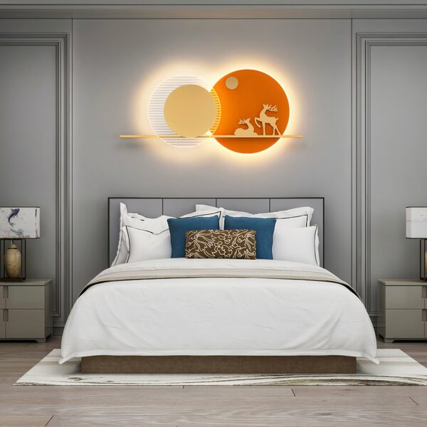 Applique murale orange avec 2 cerfs, dans 2 cercles formant comme 2 soleils superposés, au dessus d'un lit