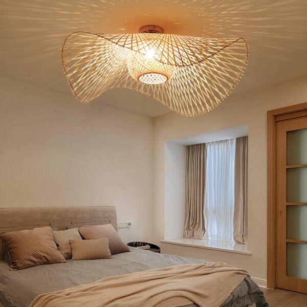 Lustre chambre adulte de style bohème en rotin allumé sur fond beige avec un lit