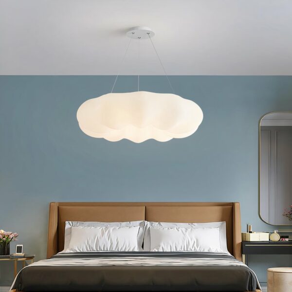 Lustre nuage suspendu blanc au design moderne sur fond bleu avec un lit