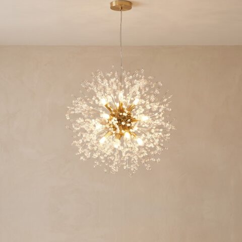 Lustre pissenlit doré de 60 cm de diamètre, allumé devant un mur beige