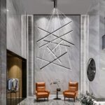 Lustre salon noir à design moderne en aluminium sur fond gris avec deux fauteuils marrons