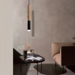 Suspension en bois LED en forme de tube de couleur noir et beige, suspendu au dessus d'une table basse