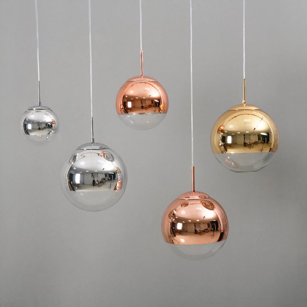 Suspension globe décorative présentée dans les couleurs devant un mur gris