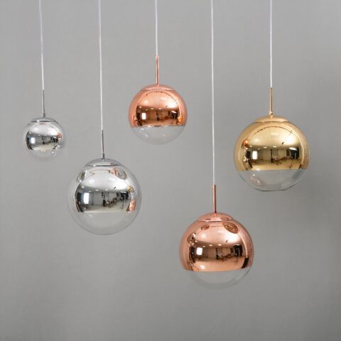 Suspension globe décorative présentée dans les couleurs devant un mur gris