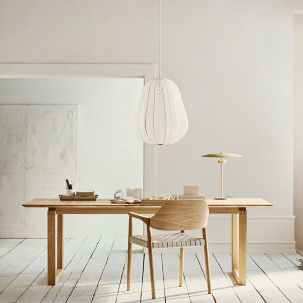 Suspension unique en tissu blanc plissé au-dessus d'un bureau en bois