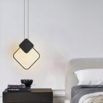 Suspension LED design minimaliste losange noir au dessus d'une table de chevet à coté d'un lit