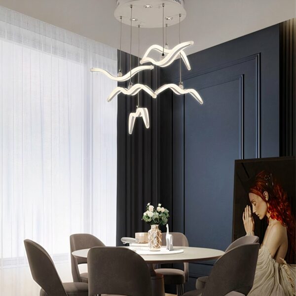 Suspension oiseau LED design nordique présentée au-dessus d'une table à manger
