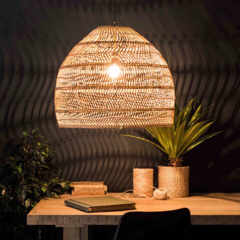 Suspension rotin naturel de style chinois pour salle à manger sur fond noir avec une table beige