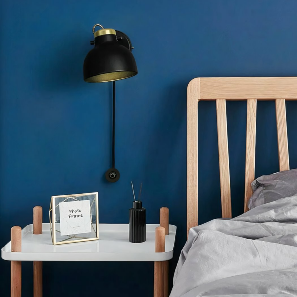 Applique murale LED tactile et réglable en aluminium sur fond bleu avec un lit et une table de nuit