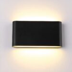 Applique murale noire de forme rectangulaire, collée au mur, avec une source lumineuse en haut et en bas, allumées. Sur un mur blanc.