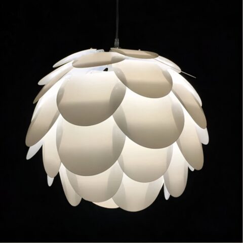 Lustre suspendu blanc en forme de boule style origami. Avec une ampoule allumée. Sur un fond noir.