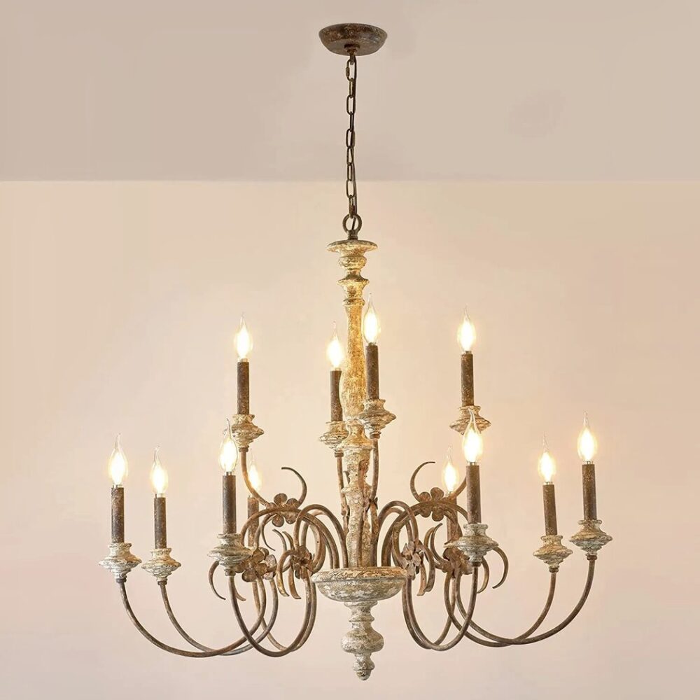 Lustre en laiton et bois style chandelier avec des bougies, les ampoules sont comme les flemmes des bougies. Elles sont allumées. Suspendu par une chaine. le fond est beige.