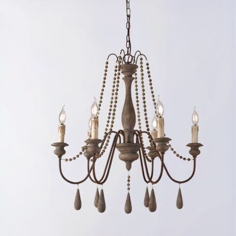 Lustre en laiton et bois avec 6 chandelles, les ampoules remplacent la flemme des bougies. Décorées de perles, des allongées qui se trouvent sous chaque chandelle et des plus petites sur le reste du lustre. Sur un fond gris.