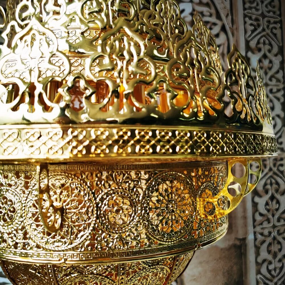 Gros plan sur la couronne supérieure en laiton ajouré à motifs arabes du lustre