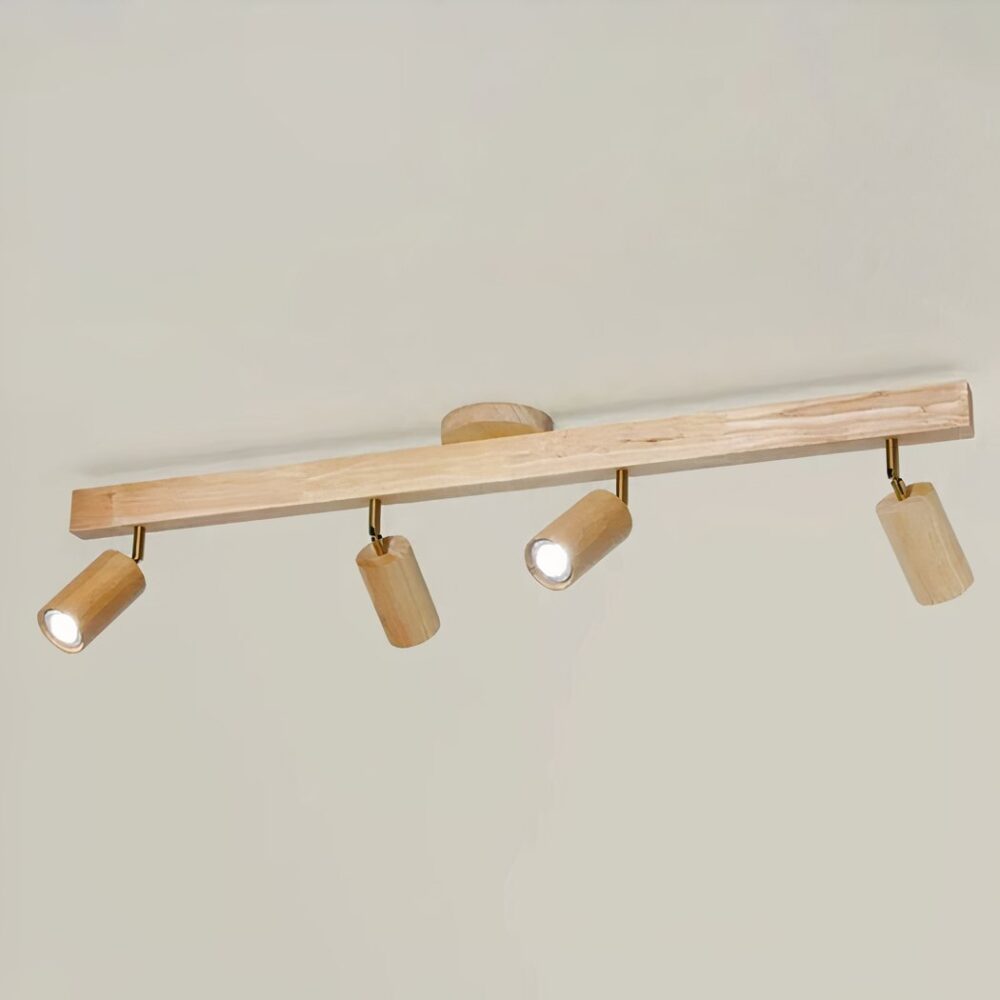 Lustre de salle de bain en bois clair composé d'un grand rectangle fin en guise de socle sur lequel il y a 4 spots lumineux espacés et rotatifs. Sur un fond beige.