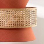Gros plan sur la bande en cannage tressé entre les pans de tissu terracotta