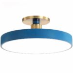 Suspension bleu canard ronde et plate proche du plafond. Composé d'un petit socle rond et doré, d'une petite tige bleu canard qui sort du socle pour se loger dans un cercle doré qui lui est collé à un grand cercle LED bleu canard sur tout le tour. Sur un fond blanc.