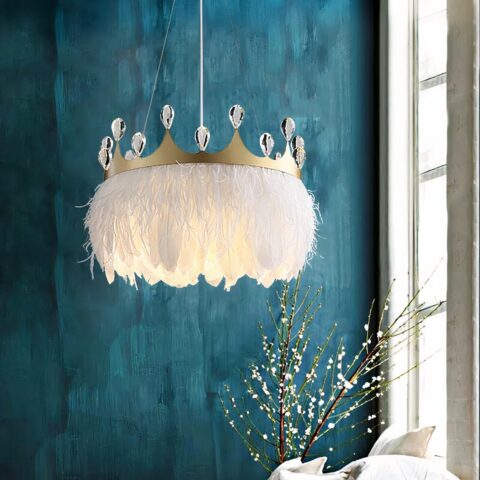 Suspension plumes blanches et couronne ornée de faux diamants. On voit derrière un mur bleu canard, sur la droite, un bout de fenêtre blanche à carreaux. Et en dessous des branches avec des fleurs dans un vase.