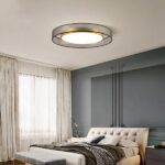Lustre chambre adulte style années 70 en tissu et métal doré accroché au plafond d'une chambre et allumé.