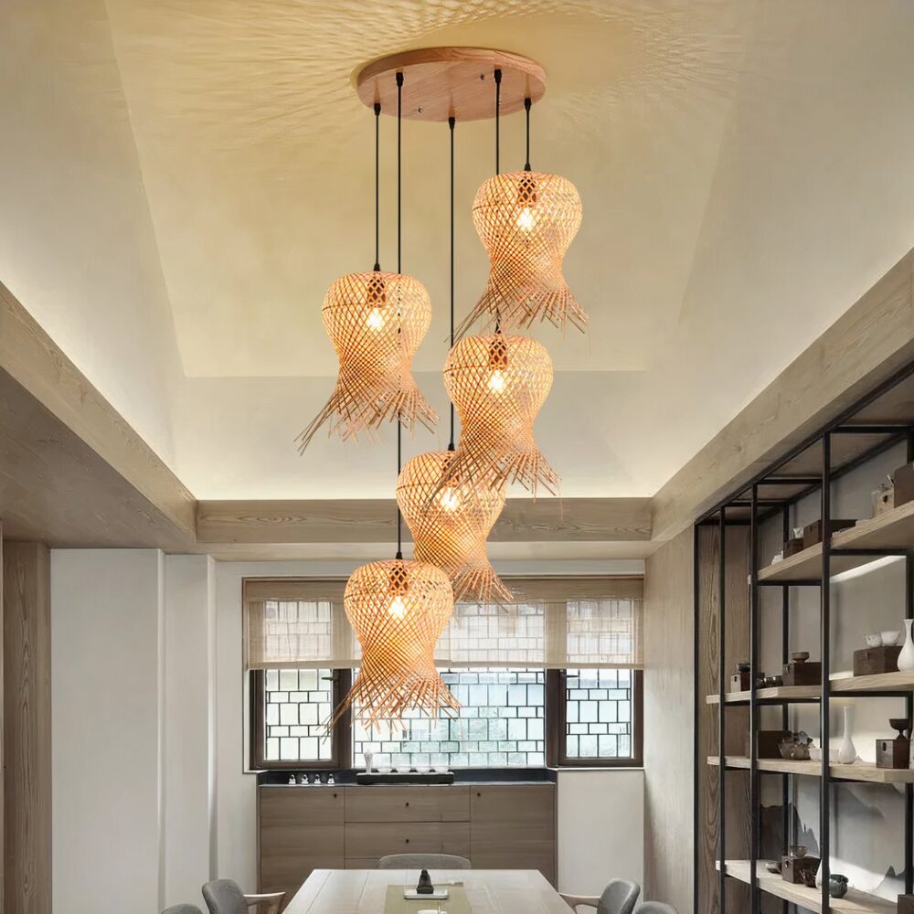 Lustre style chapeau de paille tissé à la main accroché au plafond et allumé, au-dessus d'une table de salle à manger.