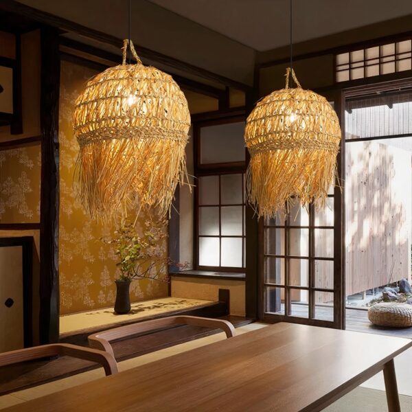 Lustre boule rétro en paille et bambou tissé à la main allumé et suspendu au-dessus d'une table de salle à manger.