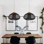 Deux suspensions coniques en rotin tressé noir au-dessus d'une table à manger