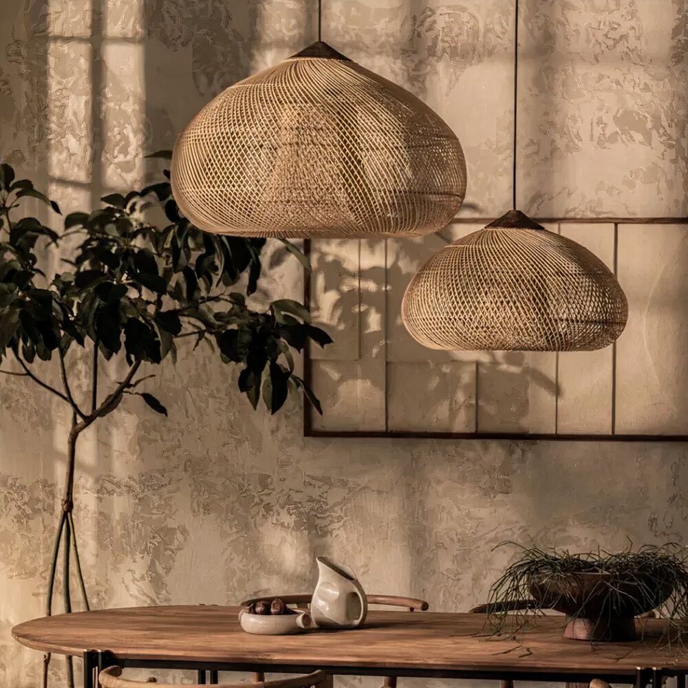 Deux suspensions coniques en rotin tressé naturel au-dessus d'une table en bois