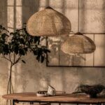 Deux suspensions coniques en rotin tressé naturel au-dessus d'une table en bois
