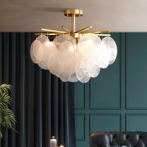 Lustre de chambre doré à pampilles de verre soufflé dans un salon, accroché au plafond et allumé.