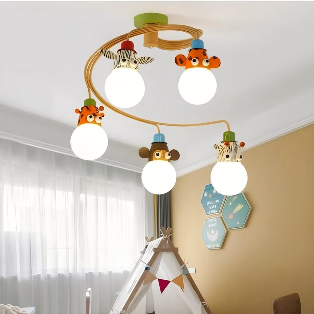 Lustre pour chambre d'enfants, en forme de spirale marron sur laquelle sont suspendues 5 têtes d'animaux avec en dessous l'ampoule allumée : girafe, zèbre, songe, tigre, vache. A gauche, fenêtre avec voile blanc, à droite, un mur beige. Entre les deux, le toit d'une maison d'enfant en tissu.