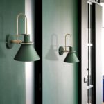 on voit un mur vert fondé et dessus deux appliques murales posées de couleur verte foncés dans le style scandinave